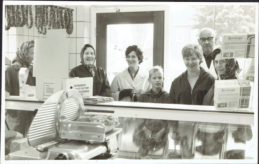 Een foto met klanten bij slagerij Koos in Albergen, tegenover de kerk. We weten niet alle namen. De mevrouw uiterst link...
